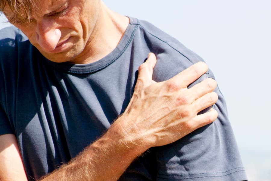 Person grasping their shoulder in pain | Humphrey Shoulder Clinic